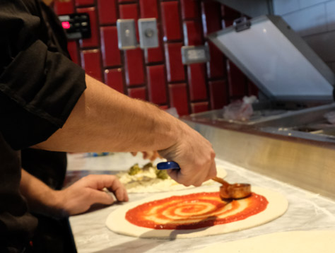 Sauce Team Member preparing a pizza