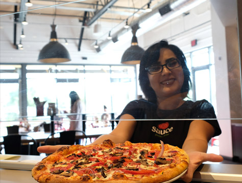 Sauce Team Member serving a pizza