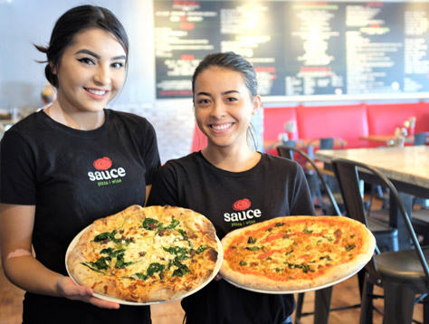 Sauce Team Members displaying pizzas